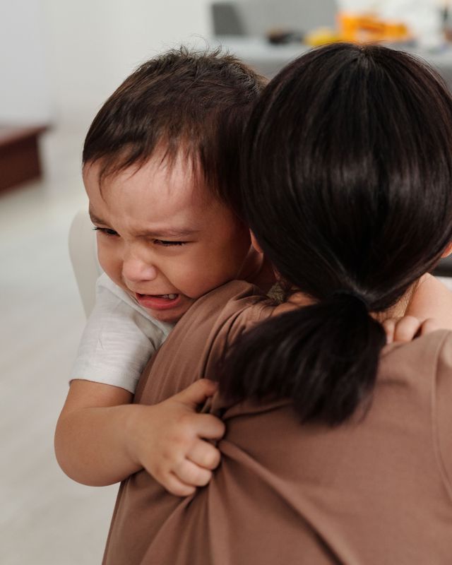 Mother comforting an upset toddler during a meltdown